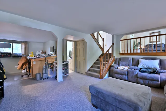 a living room with furniture and stairs