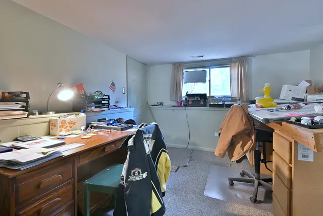 a view of a workspace with furniture and a window