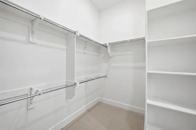 a view of a hallway with wooden floor and a window