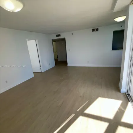 a view of a room with refrigerator and white wall