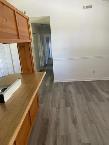 a room with kitchen island stainless steel appliances wooden floor and window