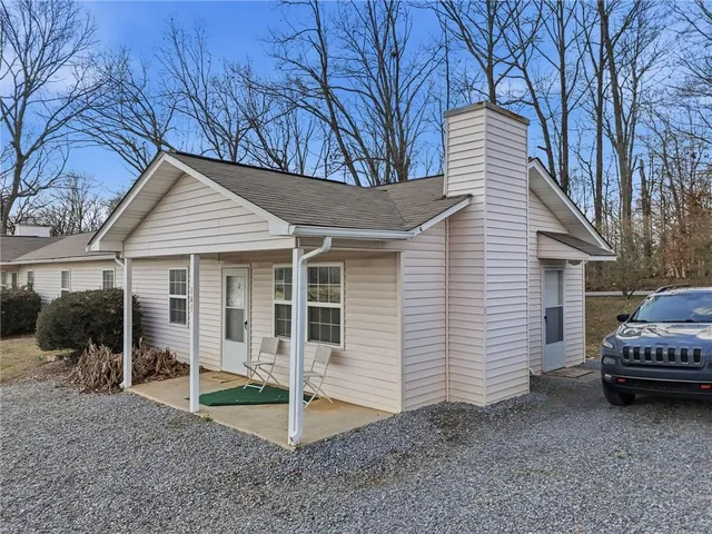 a view of a house with a big yard and large trees