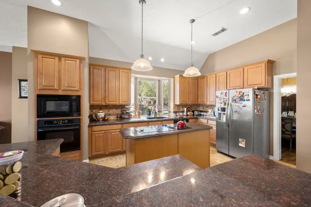 a kitchen with refrigerator and cabinets