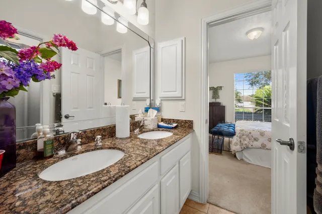 a bathroom with a granite countertop sink a mirror and a shower
