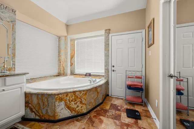 a spacious bathroom with a tub sink and mirror