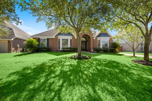 a front view of a house with yard and green space
