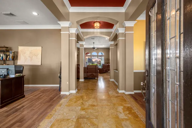 a view of a hallway with wooden floor and a living room