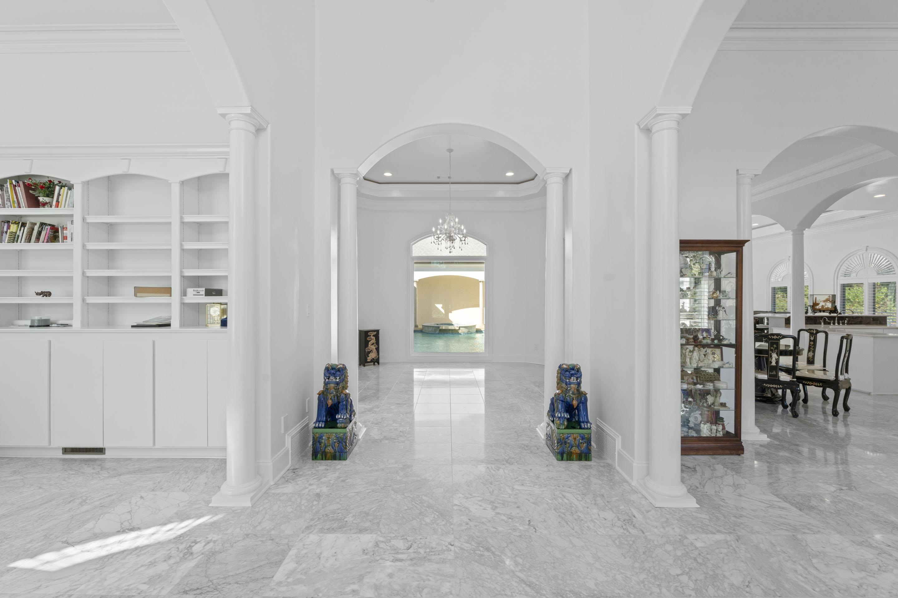 881 Bray Station Road Collierville, TN 38017 - Photo 5 of 40 Hallway with a towering ceiling, light marble finish flooring, crown molding, arched walkways, and decorative columns