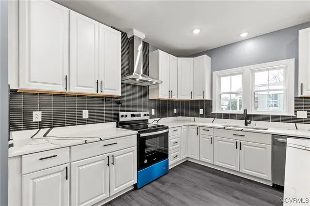 a kitchen with white cabinets appliances a sink and a window