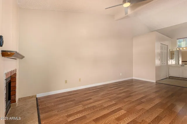an empty room with wooden floor and fireplace