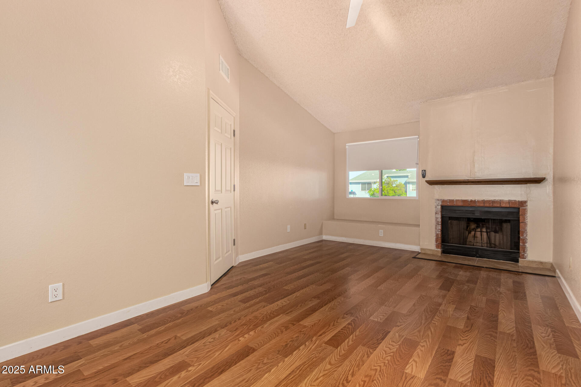 510 North Alma School Road, Unit 159 Mesa, AZ 85201 - Photo 14 of 36 an empty room with wooden floor and fireplace