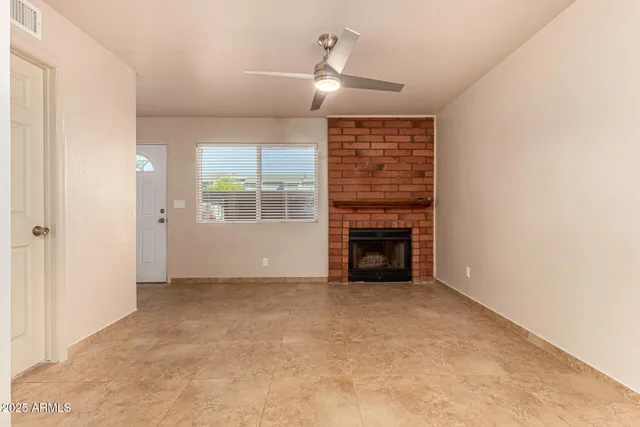an empty room with windows and fireplace