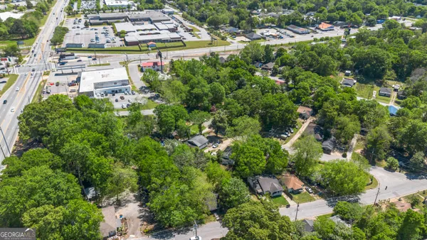 an aerial view of residential houses with outdoor space and trees
