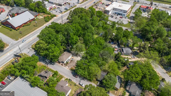 an aerial view of residential house with outdoor space and trees all around