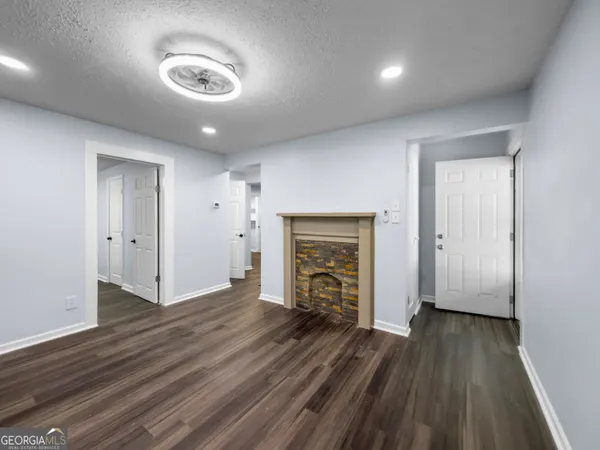 an empty room with wooden floor and a fireplace