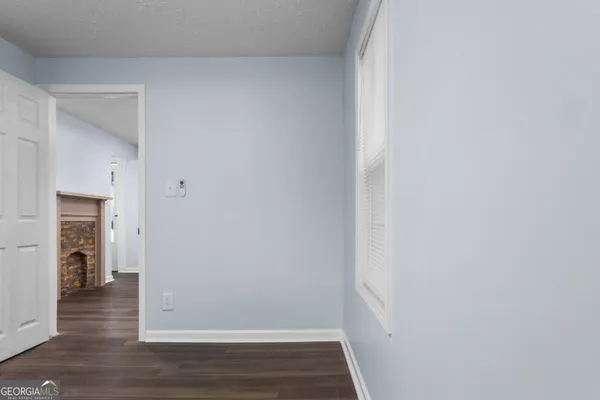 a view of hallway with wooden floor and a fireplace