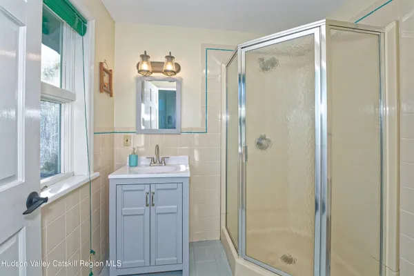 a bathroom with a double vanity sink mirror and shower