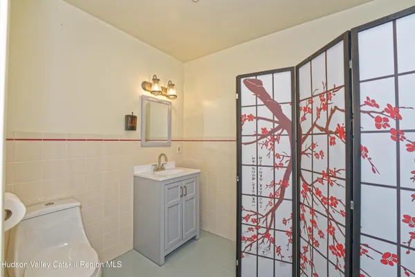a bathroom with a sink a toilet and mirror