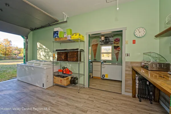 a utility room with fridge and wooden floor