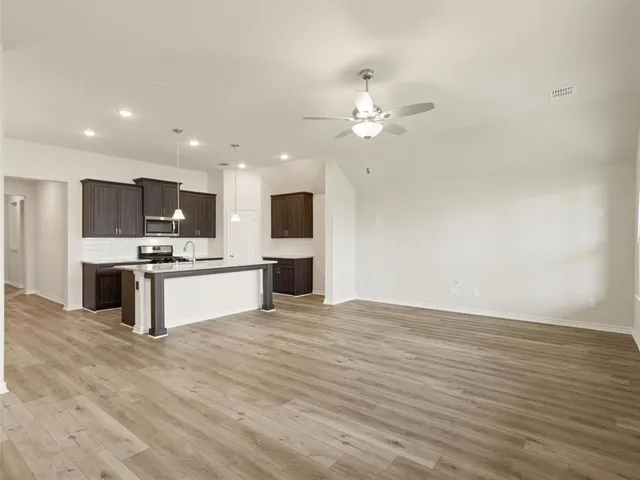 a view of kitchen with granite countertop cabinets and refrigerator