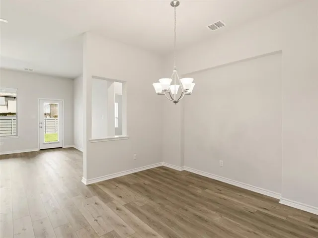 a view of a room with wooden floor and chandelier