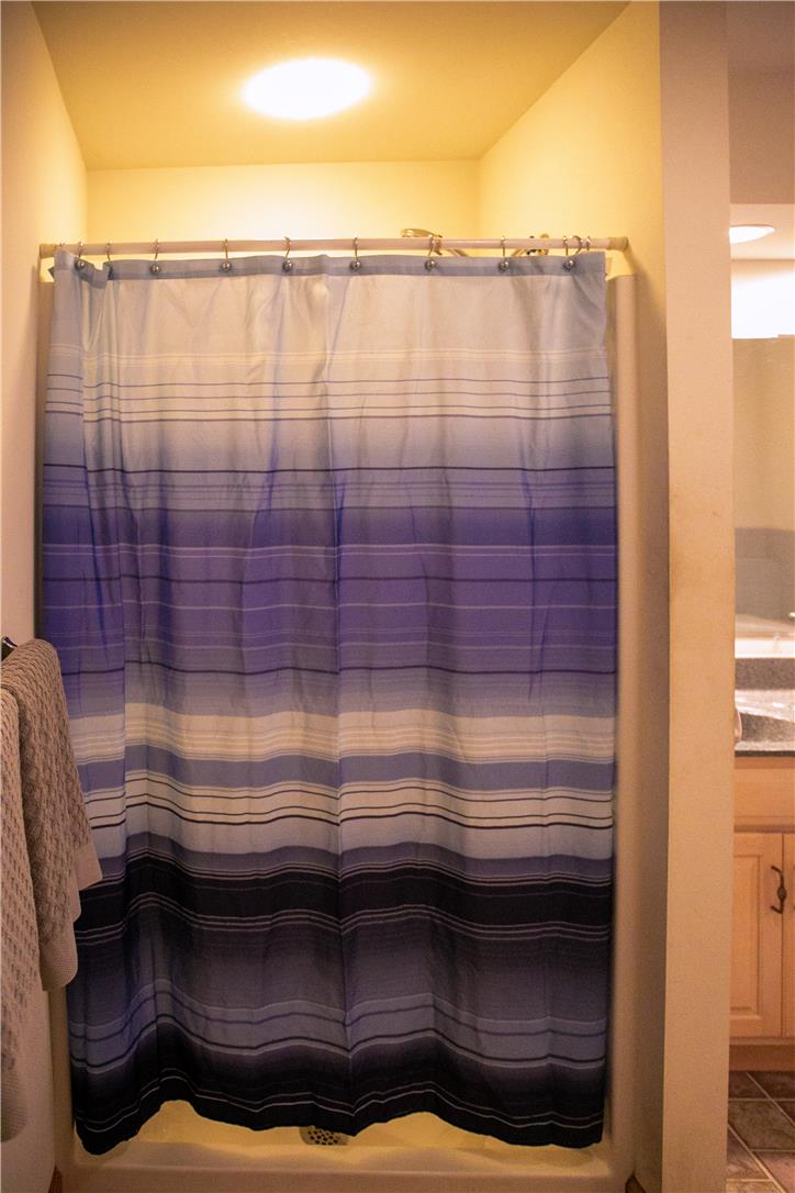 50 Anthony's Road White Haven, PA 18661 - Photo 40 of 57 A well-lit shower enclosure with a striking blue and white striped curtain.