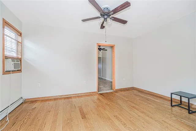 a view of a room with wooden floor and a ceiling fan