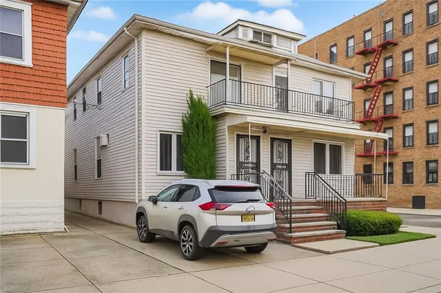 a car parked in front of a white house