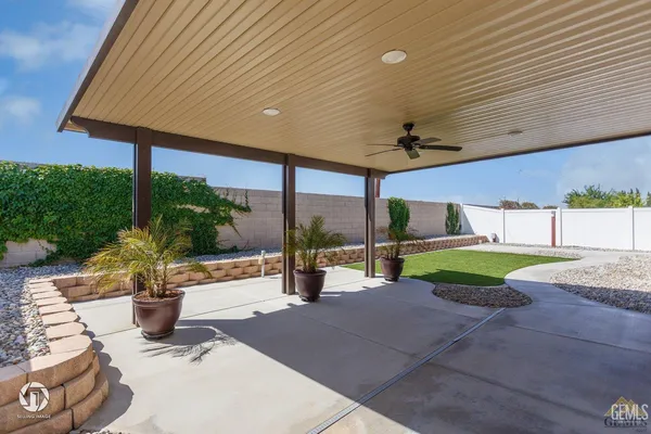 a view of a patio with a table and chairs under an umbrella