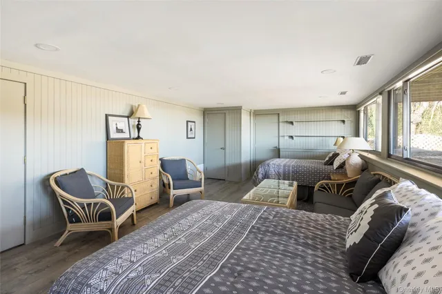 a bedroom with furniture and a large window