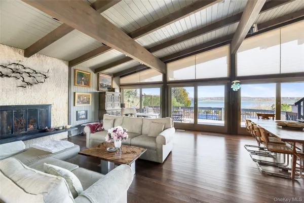 a living room with furniture large window and wooden floor