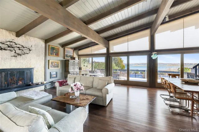 a living room with furniture large window and wooden floor