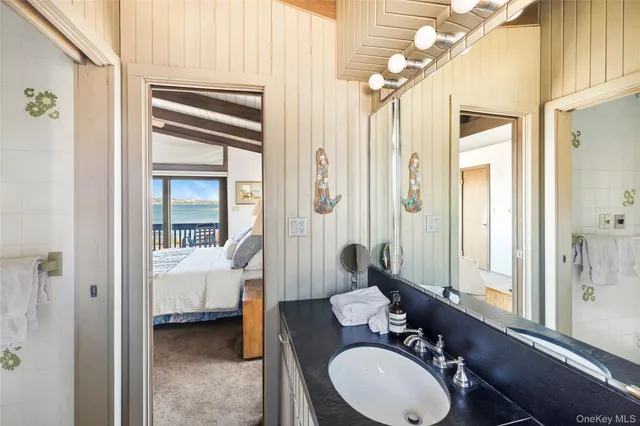 a en suite bathroom with a granite countertop sink and a mirror
