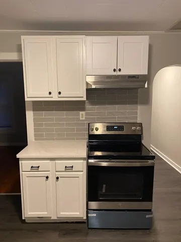 a stove top oven sitting inside of a kitchen