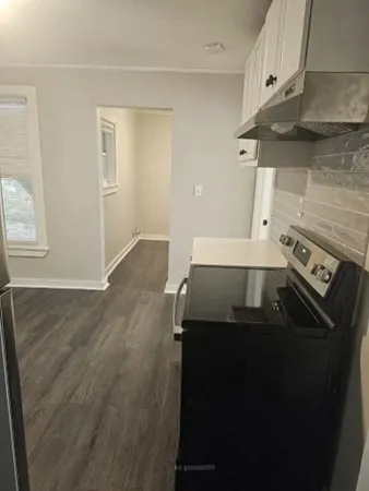 a kitchen with a stove and a wooden floor