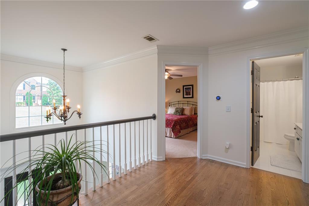 4330 Farmbrook Lane Cumming, GA 30041 - Photo 32 of 46 a view of a hallway with wooden floor and stairs