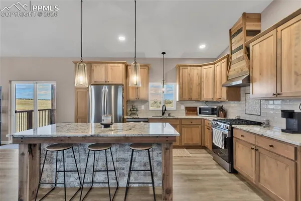 a kitchen with stainless steel appliances granite countertop sink stove refrigerator and cabinets