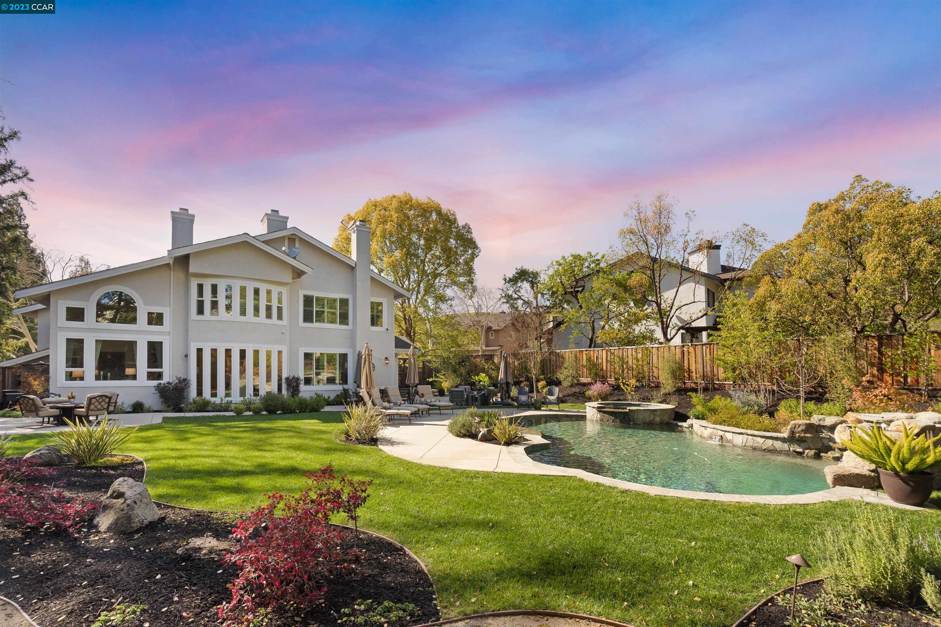 a view of a house with swimming pool and yard