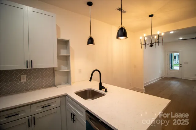 a kitchen with a sink a counter space and wooden floor
