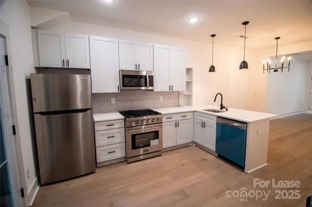 a kitchen with stainless steel appliances a refrigerator sink and cabinets