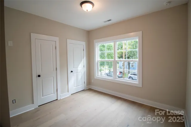 an empty room with windows and closet