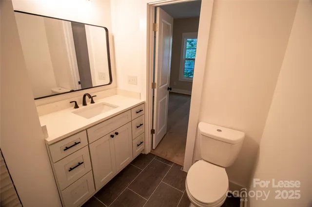a spacious bathroom with a toilet sink and mirror