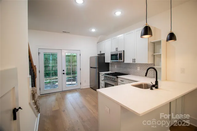 a kitchen with kitchen island a sink appliances and cabinets