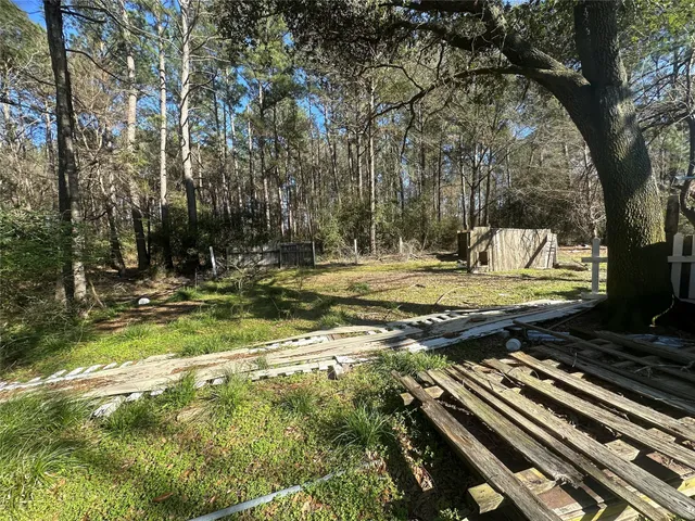 a view of a yard with wooden fence
