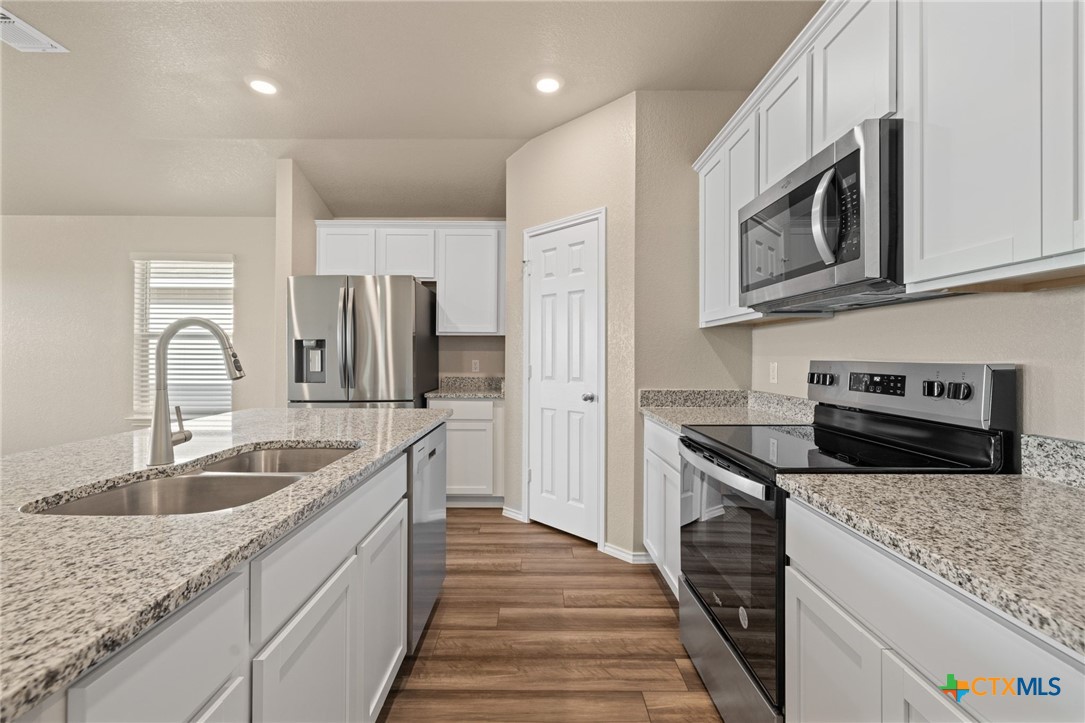 922 Stone Vly Road Temple, TX 76502 - Photo 13 of 32 a kitchen with stainless steel appliances granite countertop a sink stove and refrigerator