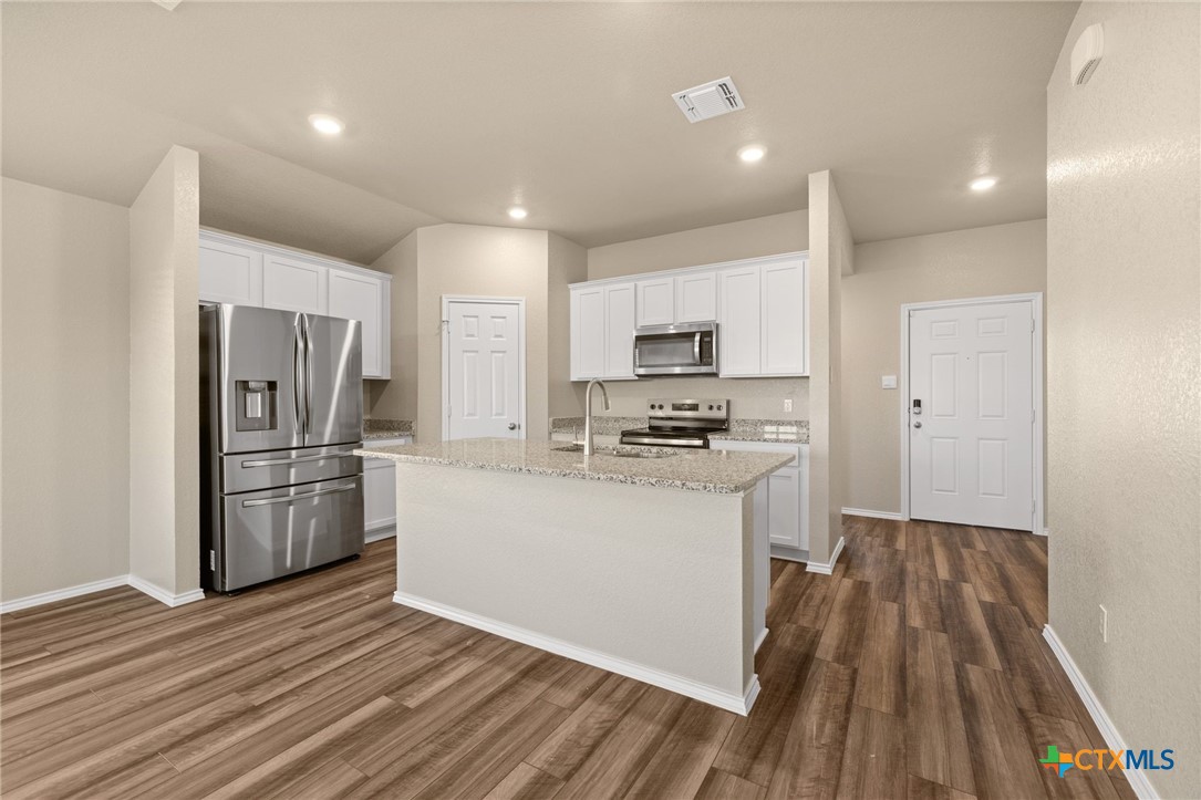 922 Stone Vly Road Temple, TX 76502 - Photo 19 of 32 a kitchen with a refrigerator a stove top oven and wooden floor