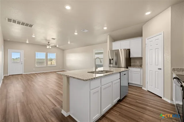 a kitchen with stainless steel appliances granite countertop a sink and cabinets