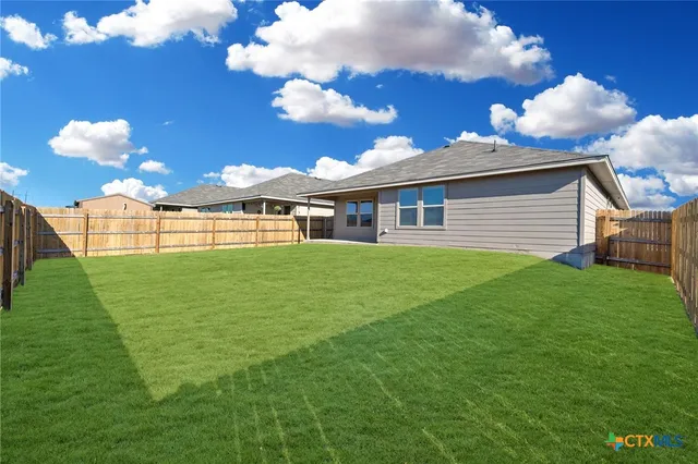 a view of a house with a backyard