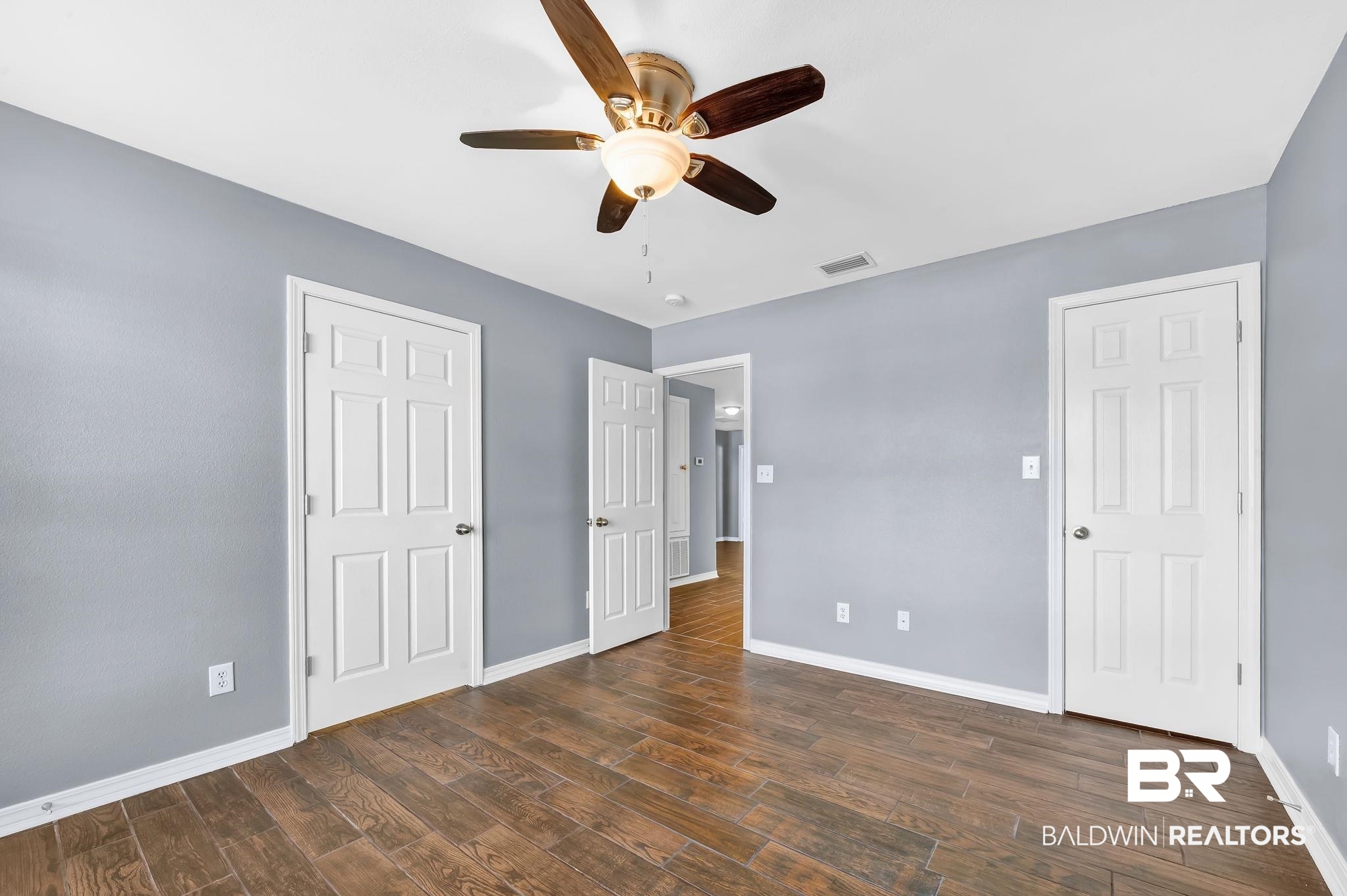 16444 Hamlet Lane Foley, AL 36535 - Photo 34 of 49 Unfurnished bedroom with dark wood-style floors, visible vents, baseboards, and a ceiling fan