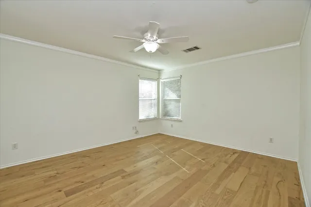 a view of a room with wooden floor and chandelier fan